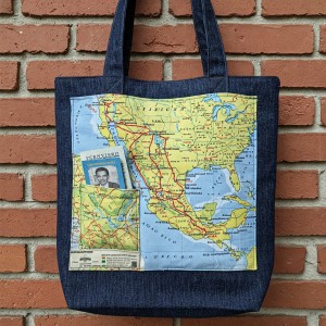 Bolsa de mezclilla reciclada con un mapa de la ruta de Chiapas a Tijuana impreso en
el frente. El mapa está superpuesto con líneas rojas que marcan las áreas peligrosas y
líneas verdes que marcan las áreas más seguras. La bolsa también tiene un pequeño
bolsillo para los documentos de identificación de un inmigrante y un mapa detallado y
colorido de los Estados Unidos impreso en la parte derecha.